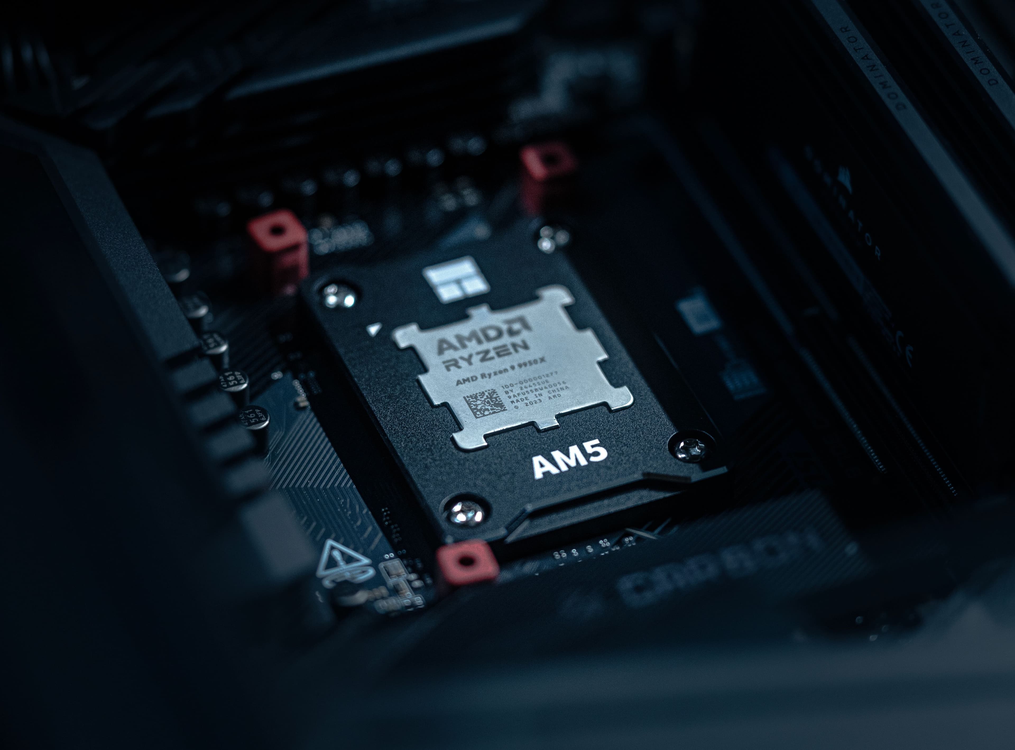 Close-up shot of an AMD Ryzen 9 9950X AM5 processor secured in a motherboard socket with a black retention frame.