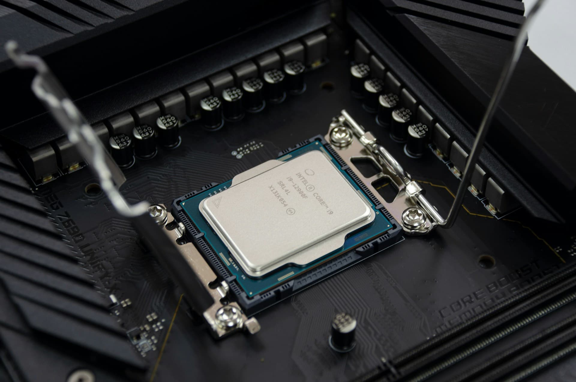 Intel Core i9 CPU sitting in an LGA socket on a motherboard with retention arm open and triangle alignment marker visible