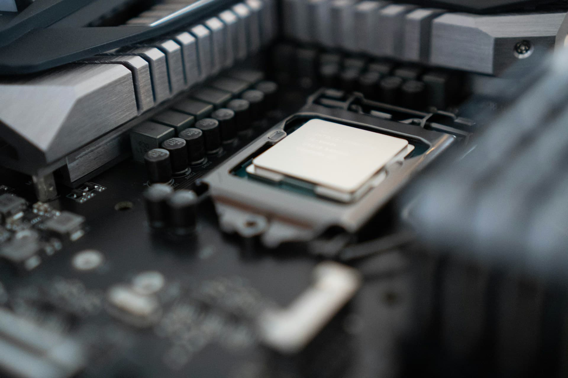 CPU installed in a motherboard socket surrounded by VRM heatsinks and capacitors